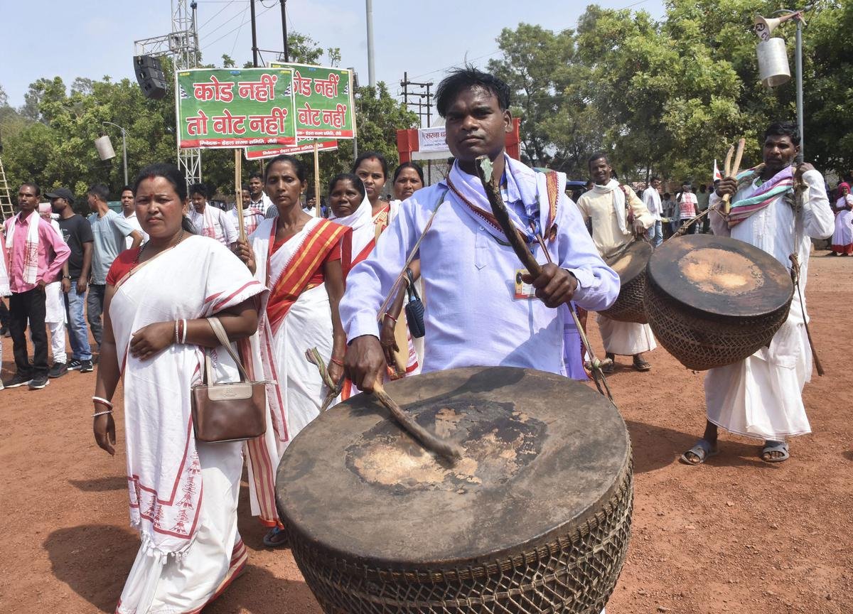 12 मार्च, 2023 रविवार को एक महारैली के दौरान पारंपरिक पोशाक पहने आदिवासी पारंपरिक ढोल 'नगाड़ा' बजाते हैं।